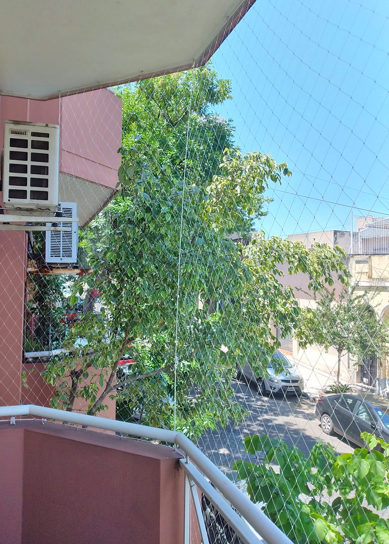 Red de seguridad en balcón de departamento sobre la calle