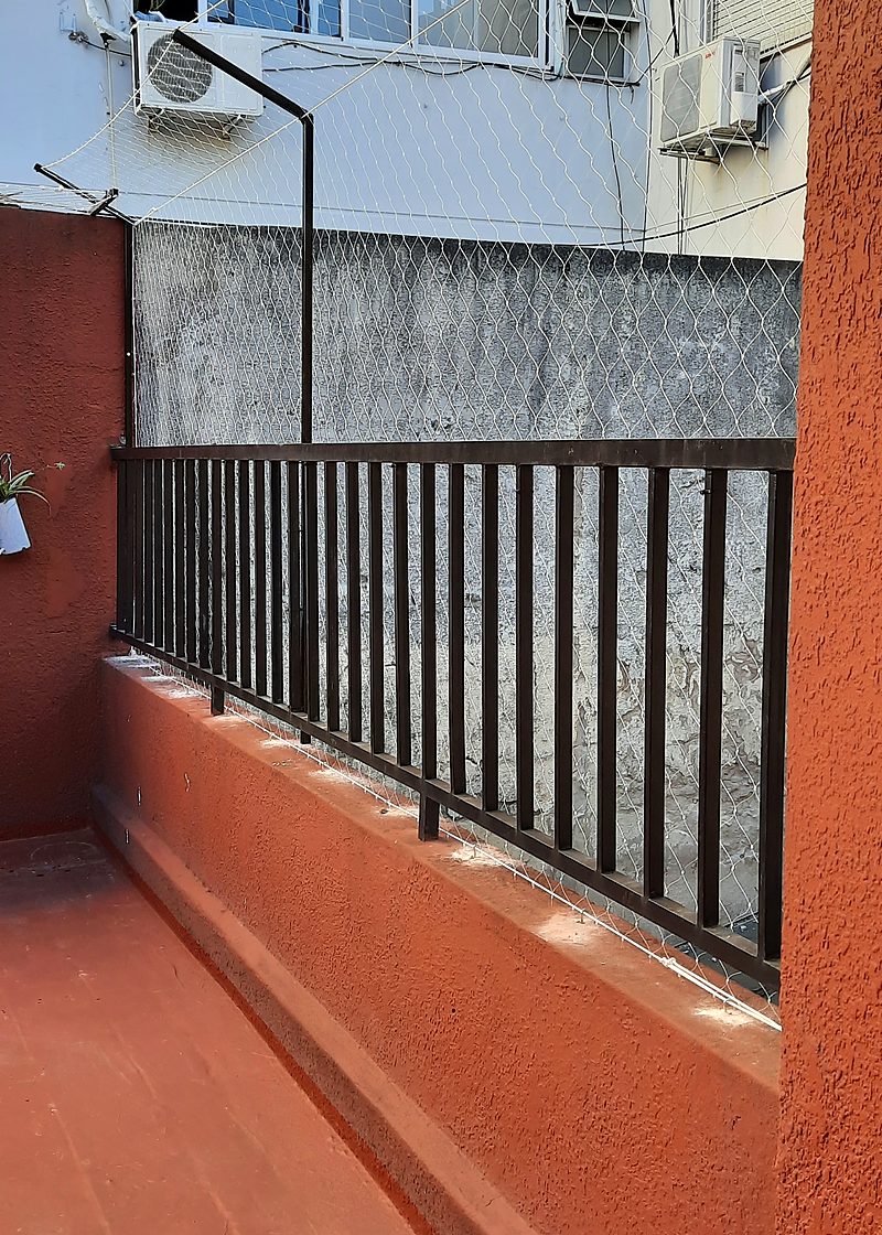 Red de seguridad instalada sobre baranda de balcón