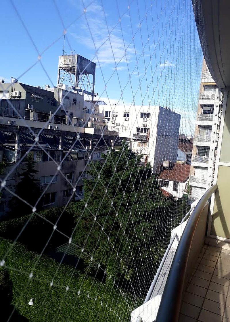 Red de seguridad en balcón de piso alto con vista a la ciudad